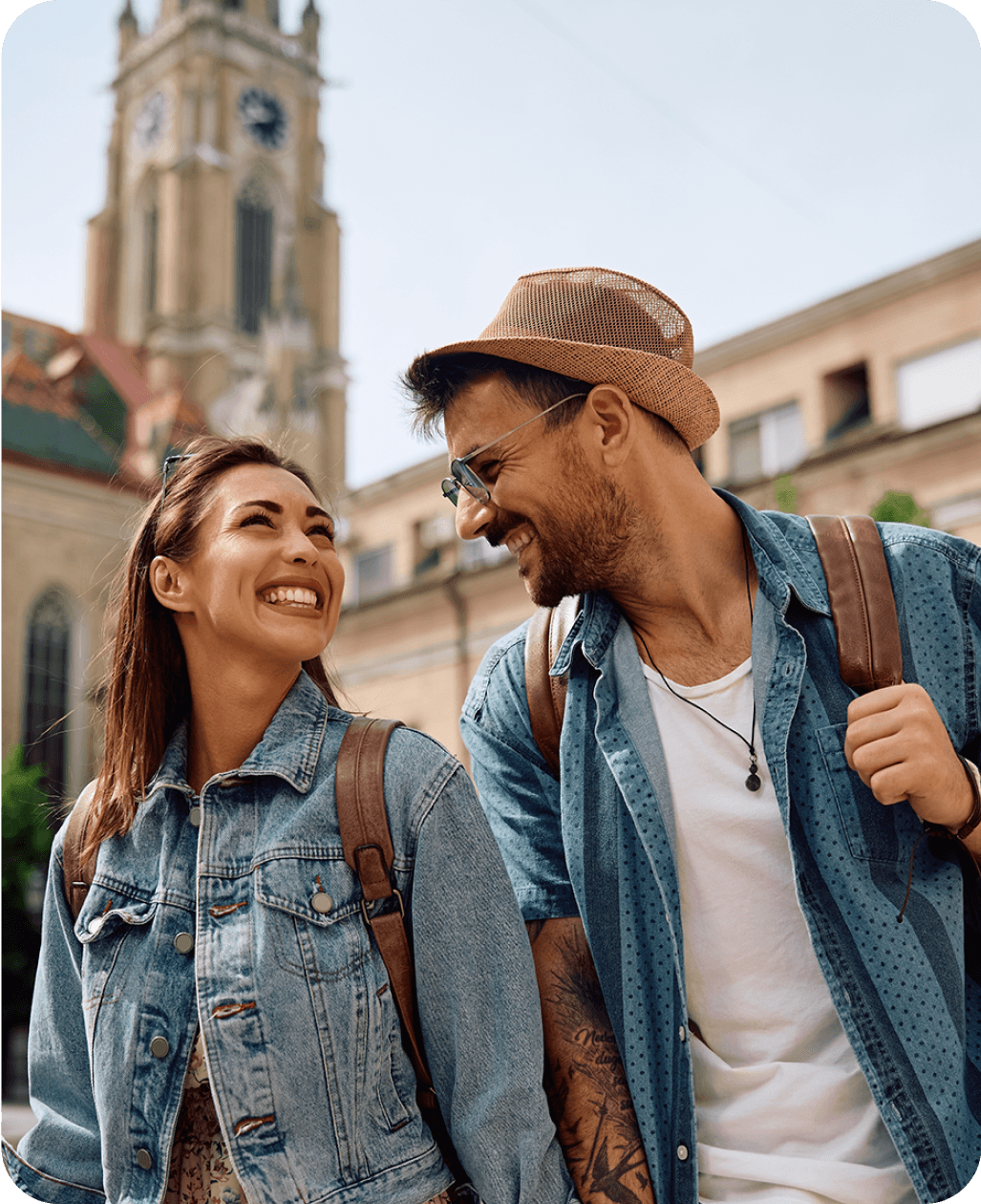 Casal sorridente, caminhando em ambiente externo, representando o uso cotidiano do idioma.