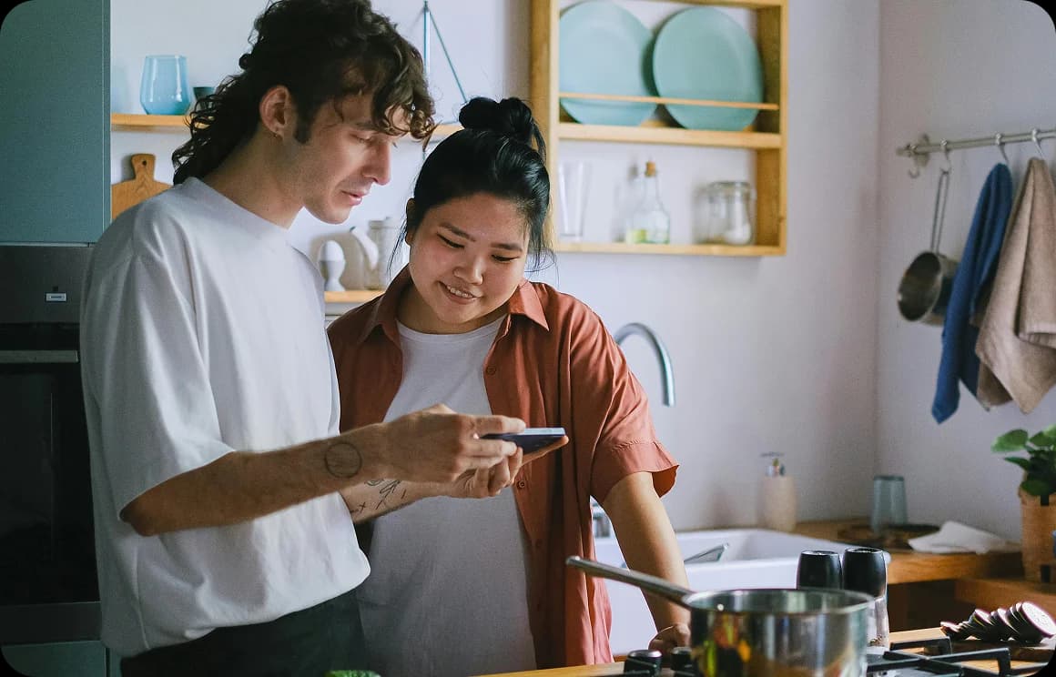 Duas pessoas aprendendo juntas usando um dispositivo móvel.